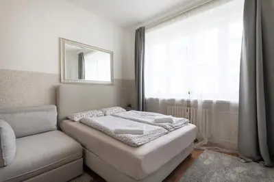 a bedroom with a bed and a couch and a window at Prague city centre in Prague
