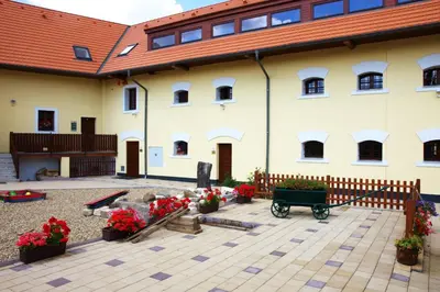 a large white building with flowers in a courtyard at Hotel Pod Sluncem in Třebíz