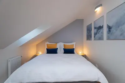 a bedroom with a white bed with blue and yellow pillows at Seven Wishes Boutique Residence by Dwellfort in Prague
