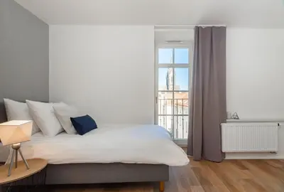 a bedroom with a bed and a large window at Seven Wishes Boutique Residence by Dwellfort in Prague
