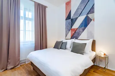 a bedroom with a large white bed and a window at Seven Wishes Boutique Residence by Dwellfort in Prague