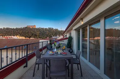 a table and chairs on a balcony with a view at Seven Wishes Boutique Residence by Dwellfort in Prague