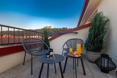 a balcony with two chairs and a plate of food at Seven Wishes Boutique Residence by Dwellfort in Prague