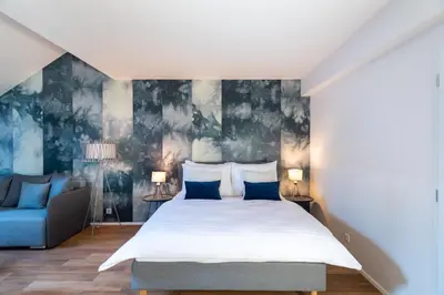 a bedroom with a bed and a blue couch at Seven Wishes Boutique Residence by Dwellfort in Prague