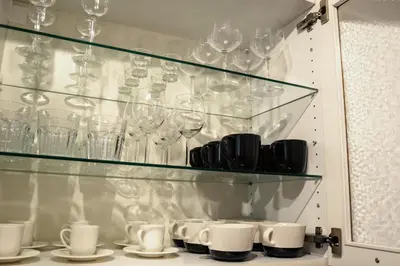 a cabinet filled with glasses and cups and plates at Apartment Gesse Kollarova in Prague