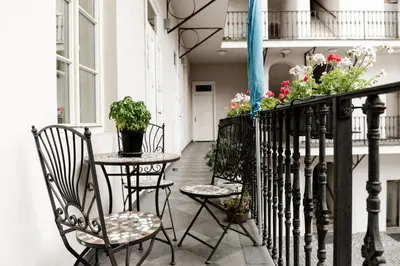 a balcony with two chairs and a table with plants at Apartment Gesse Kollarova in Prague