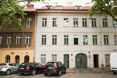a white building with cars parked in front of it at Apartment Gesse Kollarova in Prague