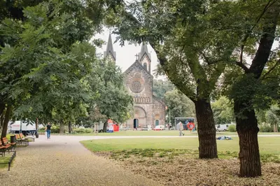 an old church with trees in front of a park at Apartment Gesse Kollarova in Prague