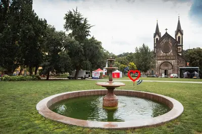 a fountain in the middle of a field with a church at Apartment Gesse Kollarova in Prague