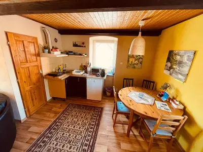 a kitchen with a wooden table and a dining room at Apartmány U kapličky in Kamýk nad Vltavou