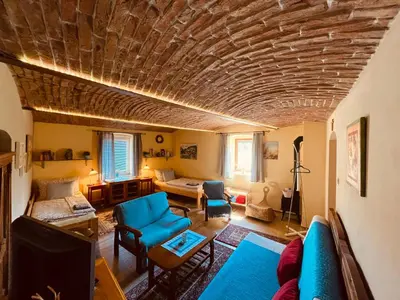 a living room with a blue couch and a stone ceiling at Apartmány U kapličky in Kamýk nad Vltavou