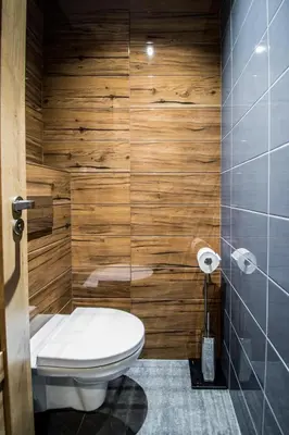 a bathroom with a toilet and wooden walls at 3BDR RUTERRA Apt with Table Football in Prague