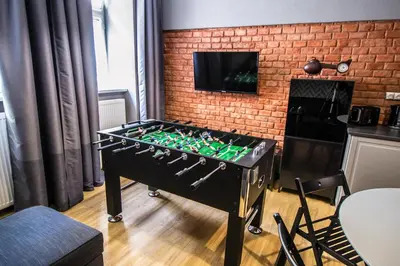 a foosball table in a room with a brick wall at 3BDR RUTERRA Apt with Table Football in Prague