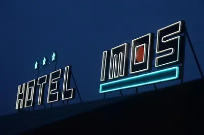 a neon sign for a hotel on a wall at Hotel Imos in Prague