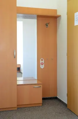 a room with a wooden cabinet and a window at Hotel Imos in Prague
