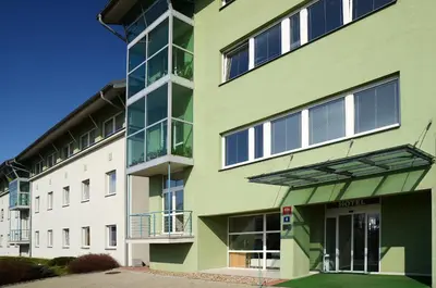 an apartment building with green and white at Hotel Imos in Prague