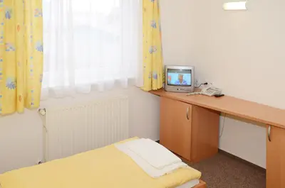 a bedroom with a desk with a small television on it at Hotel Imos in Prague