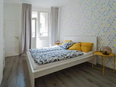 a bedroom with a bed with a blue patterned wall at Apartment U Pujcovny 6 in Prague