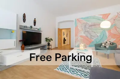 a living room with a tv and a mural at Stay Inn Apartments Naplavka in Prague