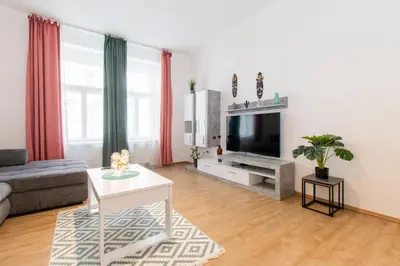 a living room with a couch and a tv at Stay Inn Apartments Naplavka in Prague