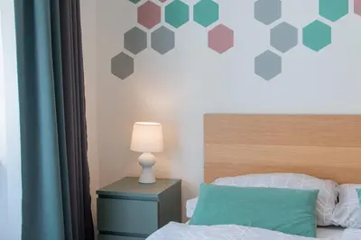 a bedroom with a bed and a table with a lamp at Stay Inn Apartments Naplavka in Prague