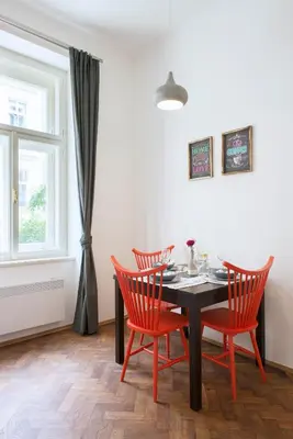a dining room with a black table and four red chairs at Kent Ridge Loft (Lublanska) in Prague