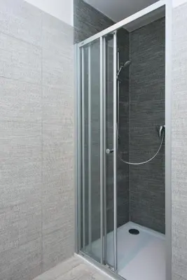 a shower with a glass door in a bathroom at Kent Ridge Loft (Lublanska) in Prague
