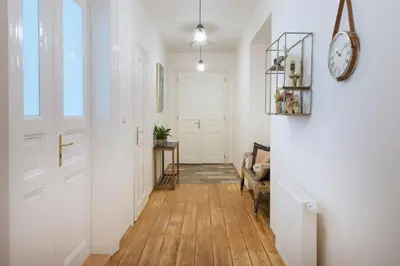 a hallway with white walls and a clock on the wall at Kent Ridge Loft (Lublanska) in Prague