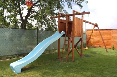 a playground with a blue slide in a yard at Lovely apartment, Garden, Parking, Wifi, Netflix in Prague