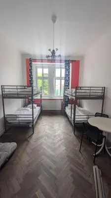 a room with three bunk beds and a table at Clown and Bard Hostel in Prague
