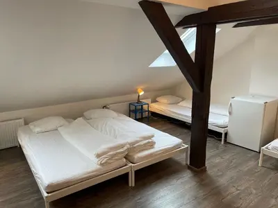 a bedroom with two white beds in a attic at Clown and Bard Hostel in Prague