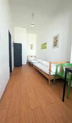 a room with several beds and a wooden floor at Clown and Bard Hostel in Prague
