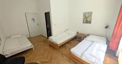 a room with three beds and a mirror at Clown and Bard Hostel in Prague