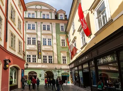 a group of people walking down a street with buildings at Karlova 25 Apartments in Prague