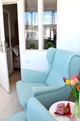 a blue chair and a table with a vase of flowers at Prague city centre apartment Radka1 in Prague