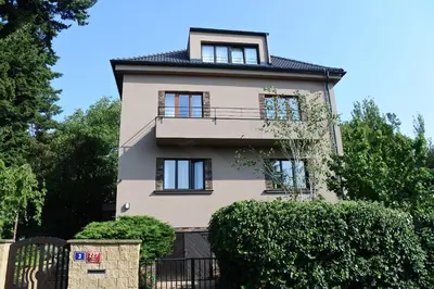 a tall building with windows and a fence at APARTMÁN V ZAHRADĚ PRAHA TROJA - APARTMENT IN THE GARDEN PRAGUE Troja in Prague