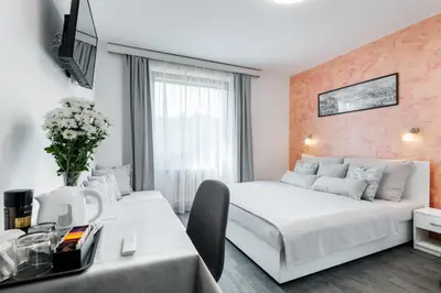 a hotel room with two beds and a table at A.V.E. Pension Kliská in Prague