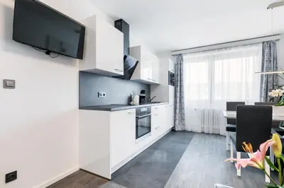 a kitchen and dining room with a tv on a wall at A.V.E. Pension Kliská in Prague