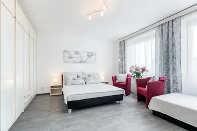 a bedroom with a bed and two chairs at A.V.E. Pension Kliská in Prague
