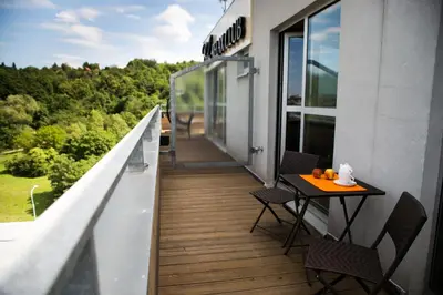 a balcony with a table and chairs on a building at Balu Apartments in Prague