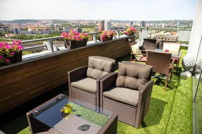 two chairs and a table on a balcony with a view at Balu Apartments in Prague