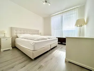 a white bedroom with a bed and a window at Balu Apartments in Prague