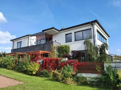 a large white house with a garden in front of it at Apartments Severka in Prague