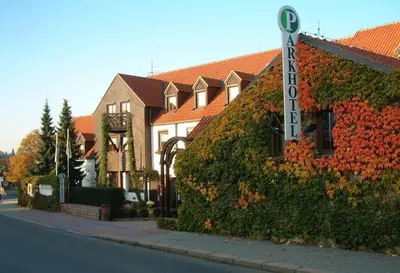 a ivy covered building with a sign in front of it at Park Hotel Pruhonice in Pruhonice