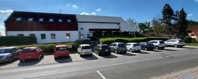 a row of cars parked in a parking lot next to a building at Park Hotel Pruhonice in Pruhonice