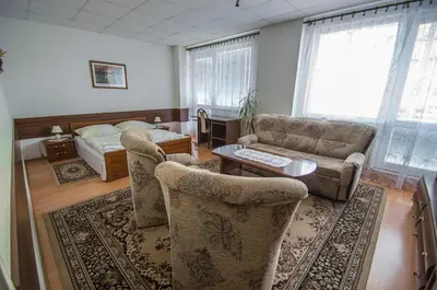 a living room with a couch and a table at Hotel Sport in Štětí