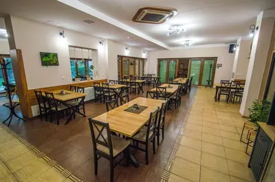 a restaurant with wooden tables and chairs in a room at Hotel Sport in Štětí