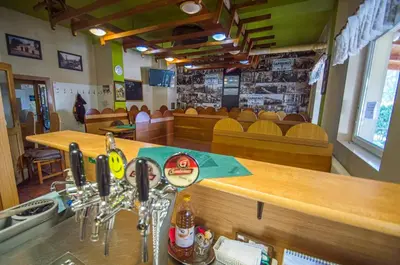 a bar in a restaurant with a counter and chairs at Hotel Sport in Štětí