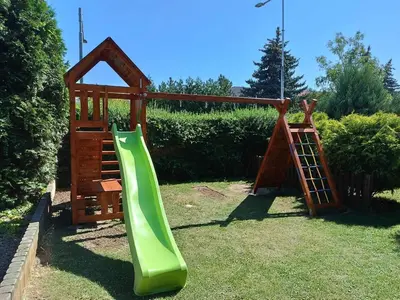 a playground with a green slide in the grass at Hotel Sport in Štětí