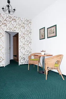 a dining room with a table and chairs and a wall at Penzion Oáza in Štětí